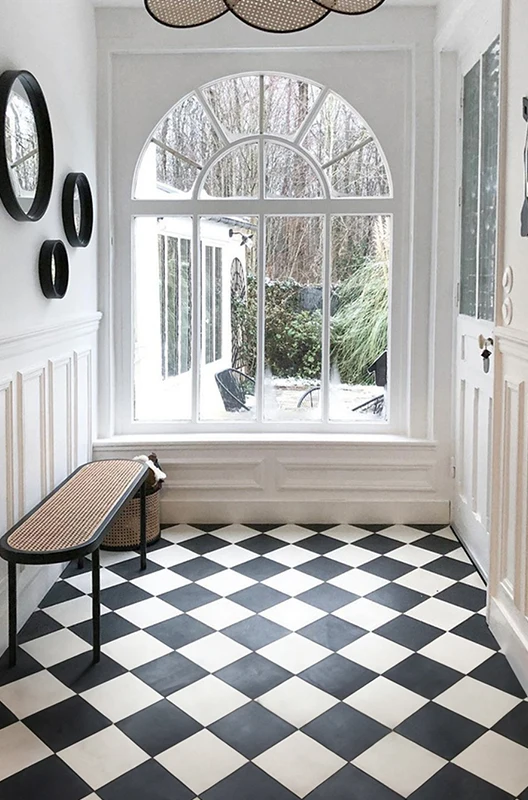 A hallways with black and white cement tiles
